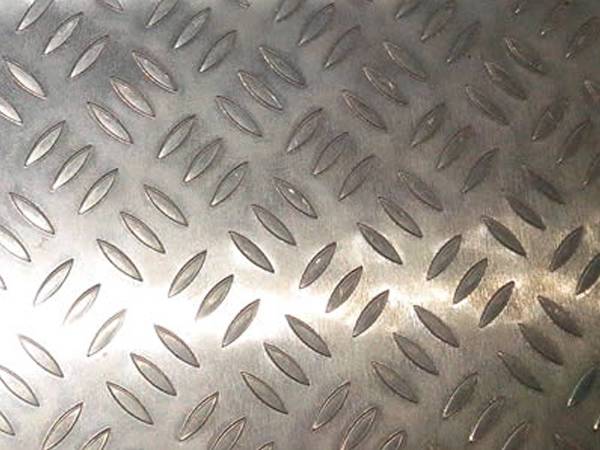 A piece of aluminum checker plate with raised three bar projections.