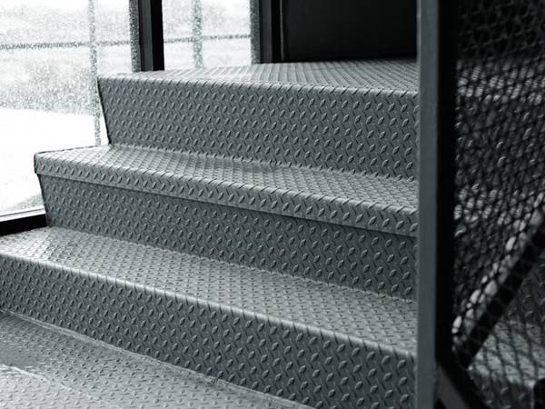 A flight of stairs is made of aluminum checker plate.